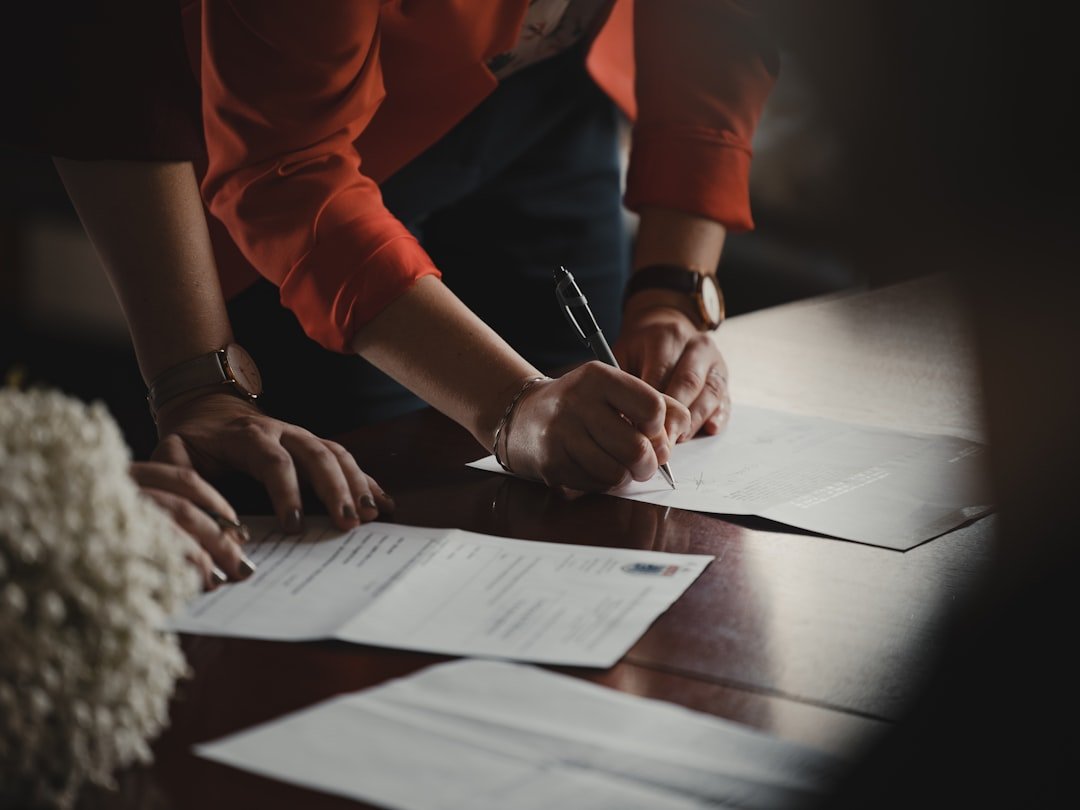 Professional reviewing contract paperwork using Claude AI prompts to summarize documents