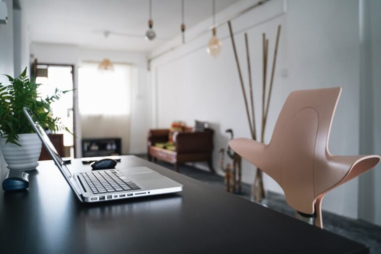 Real estate agent using ChatGPT prompts on a laptop to write property descriptions
