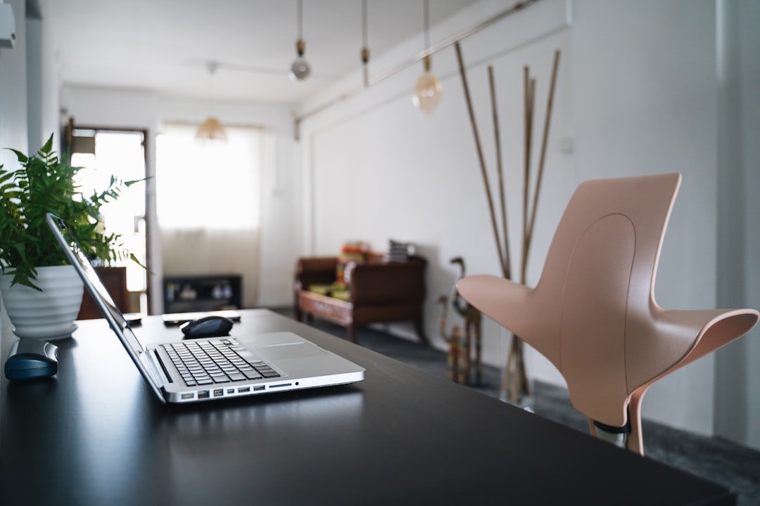 Real estate agent using ChatGPT prompts on a laptop to write property descriptions